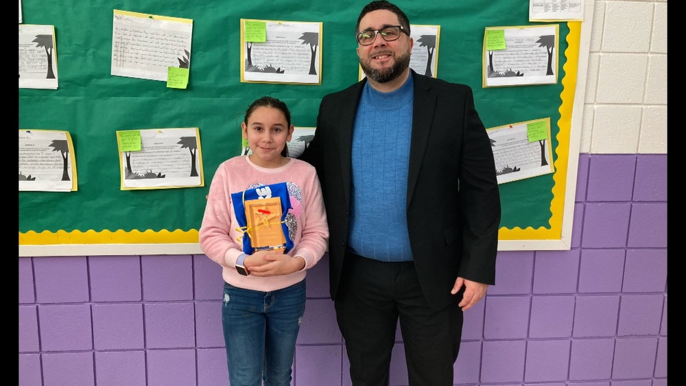 5th grader Sophia Bonilla stands with her award next to Superintendent Anthony Soto