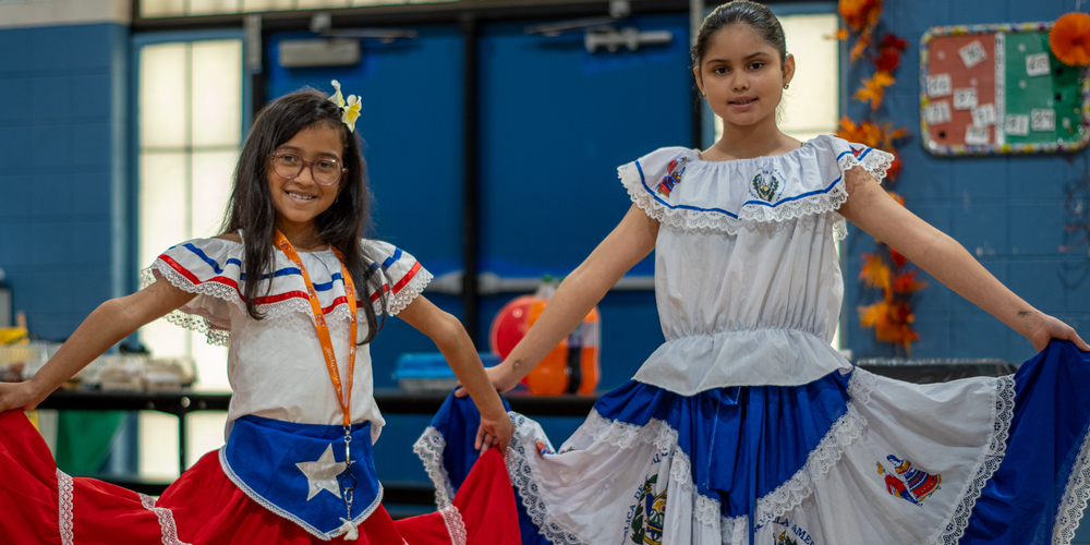 Two students wearing traditional clothing of their culture.