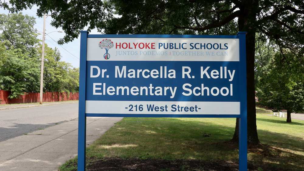 Dr. Marcella R. Kelly Elementary School street sign in front of shady tree