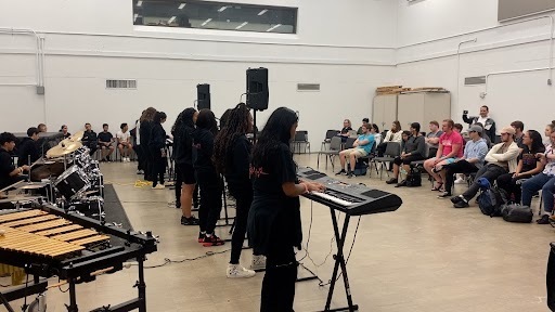 Student musicians performing on keyboards for audience