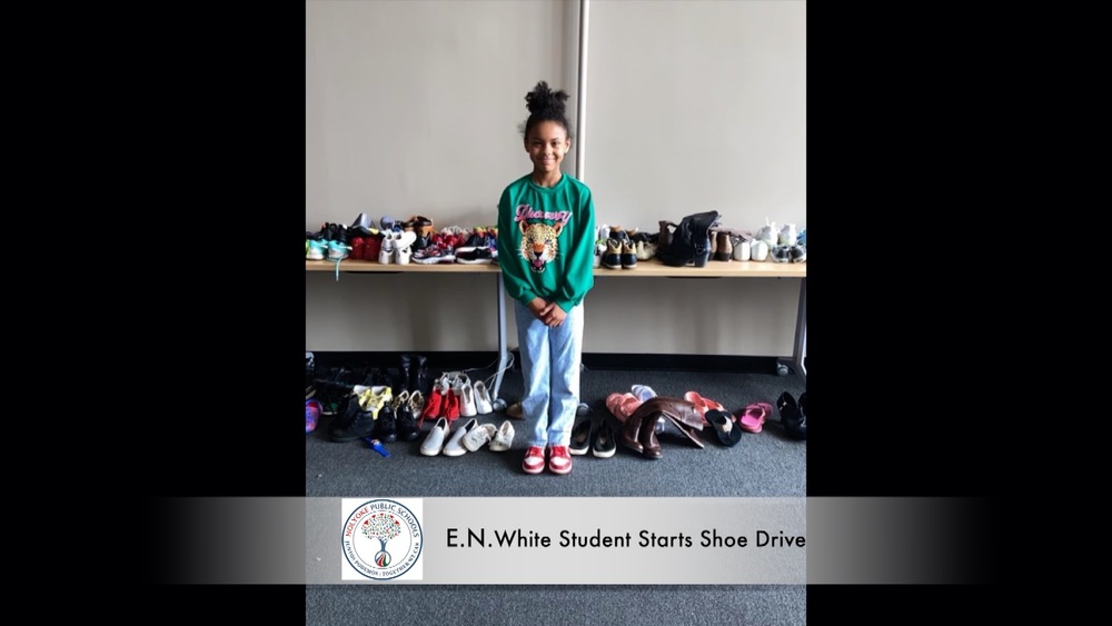 4th grade student Autumn Stark stands  with all the shoes she has collected.