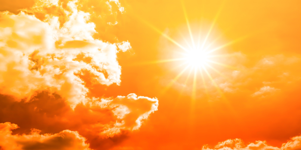 Orange sky with intense clouds and sun with rays