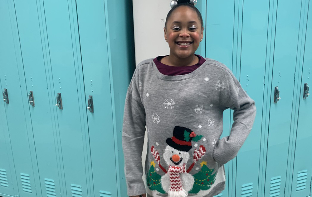Layla Barnett smiles while wearing a snowman sweater
