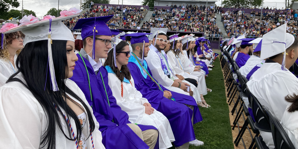 Graduates in caps and gowns sitting in rows