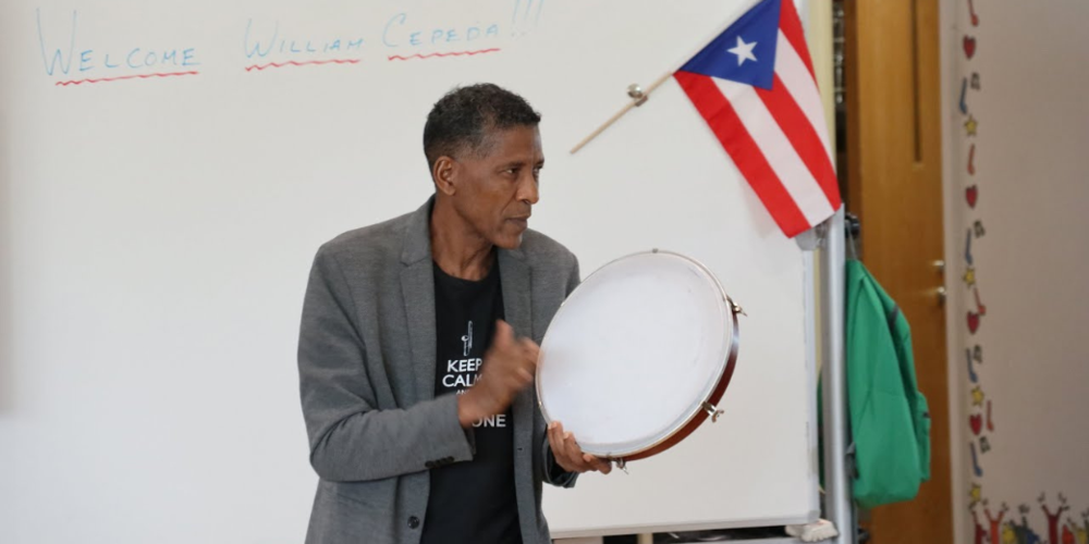 Image of William Cepeda playing playing the tambourine. 
