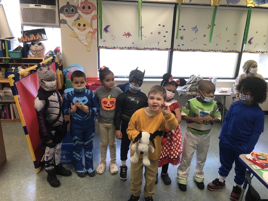 Group of small students in classroom with their halloween costumes. 