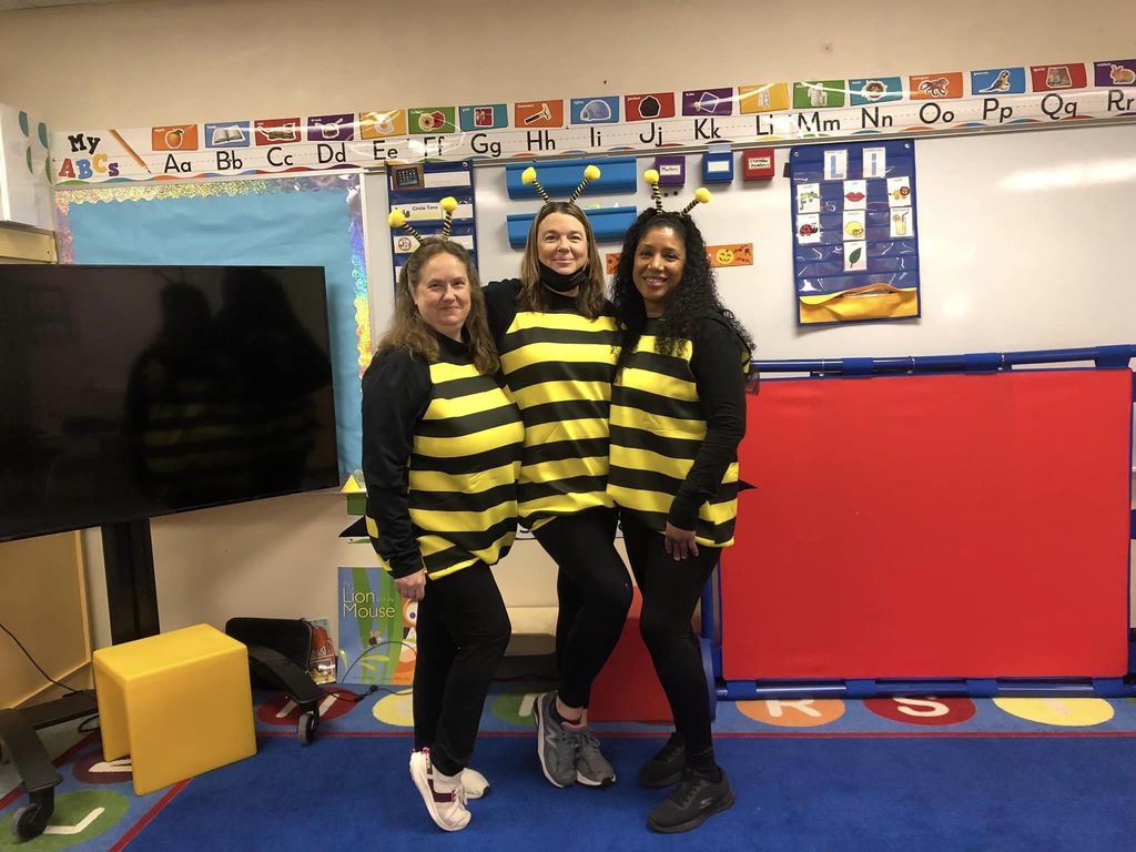 Three Donahue staff members dressed in bee costumes. 