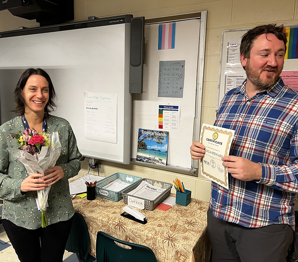 Two educators, one holding flowers and one holding a certificate.