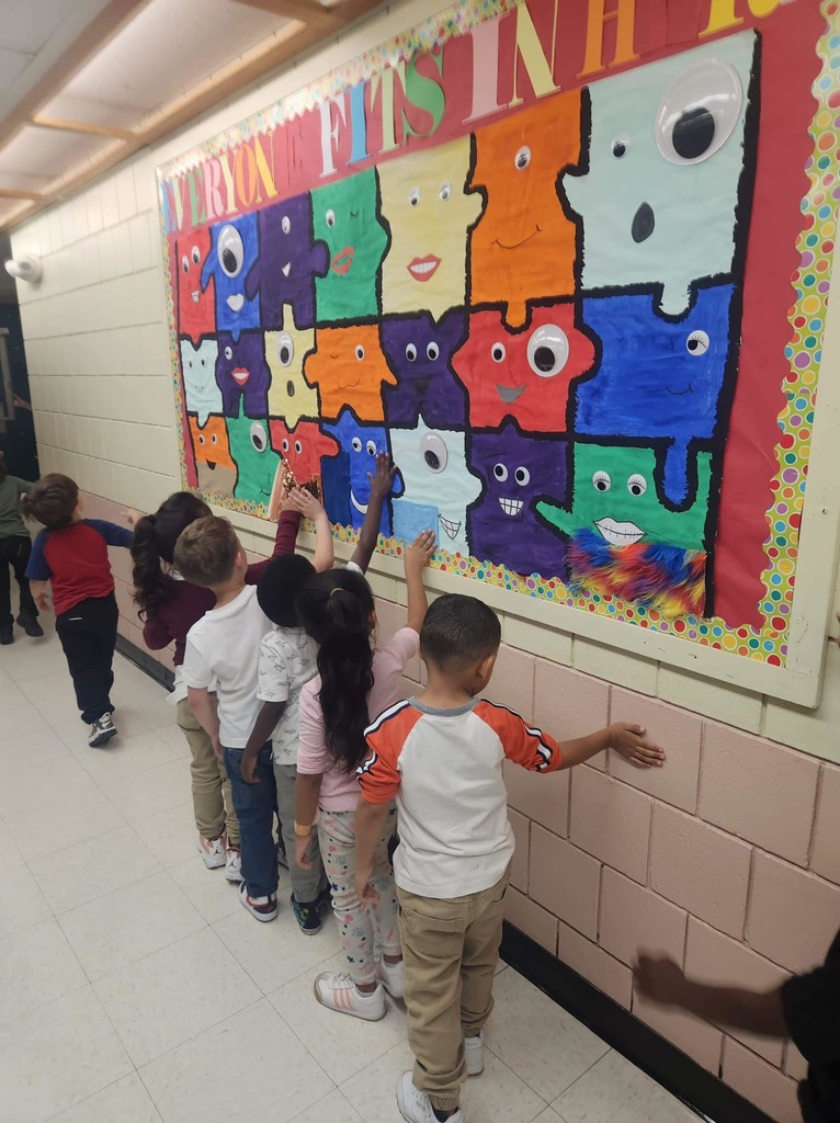 Students in the hallway interacting with a sensory board. 