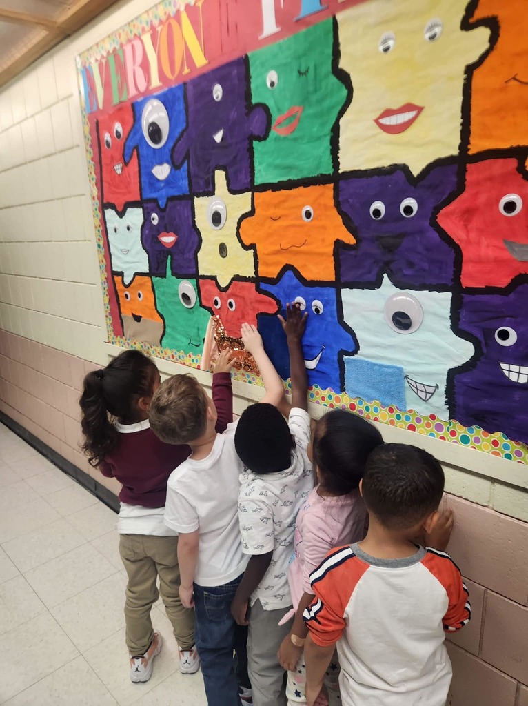 Students in the hallway interacting with a sensory board. 