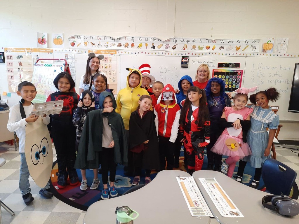 Group of students in a class posing with their Halloween Costumes.