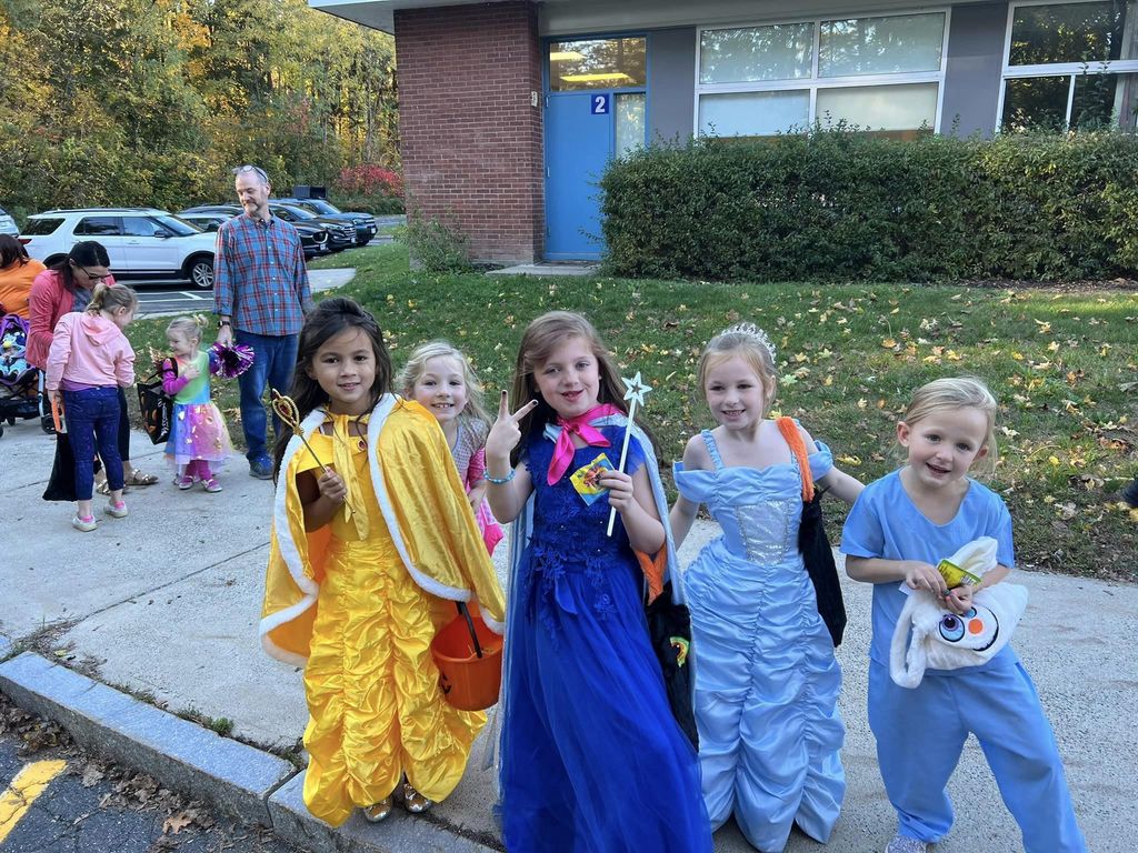 Group of five young students in their halloween outfits.