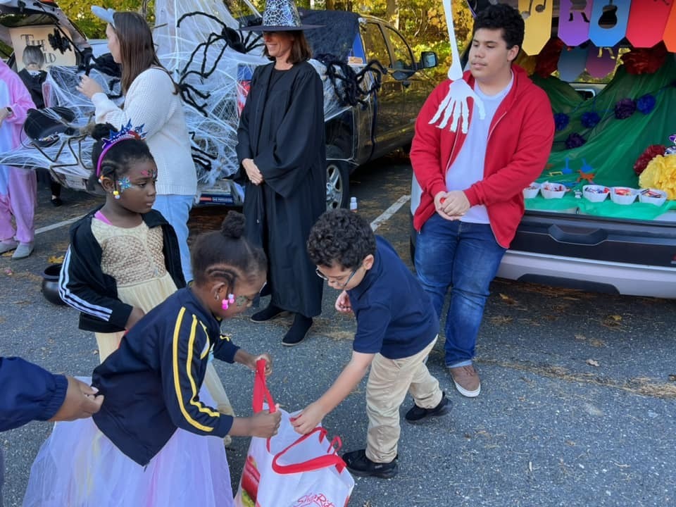 Students participating in the trunk or treat activity, receiving candy
