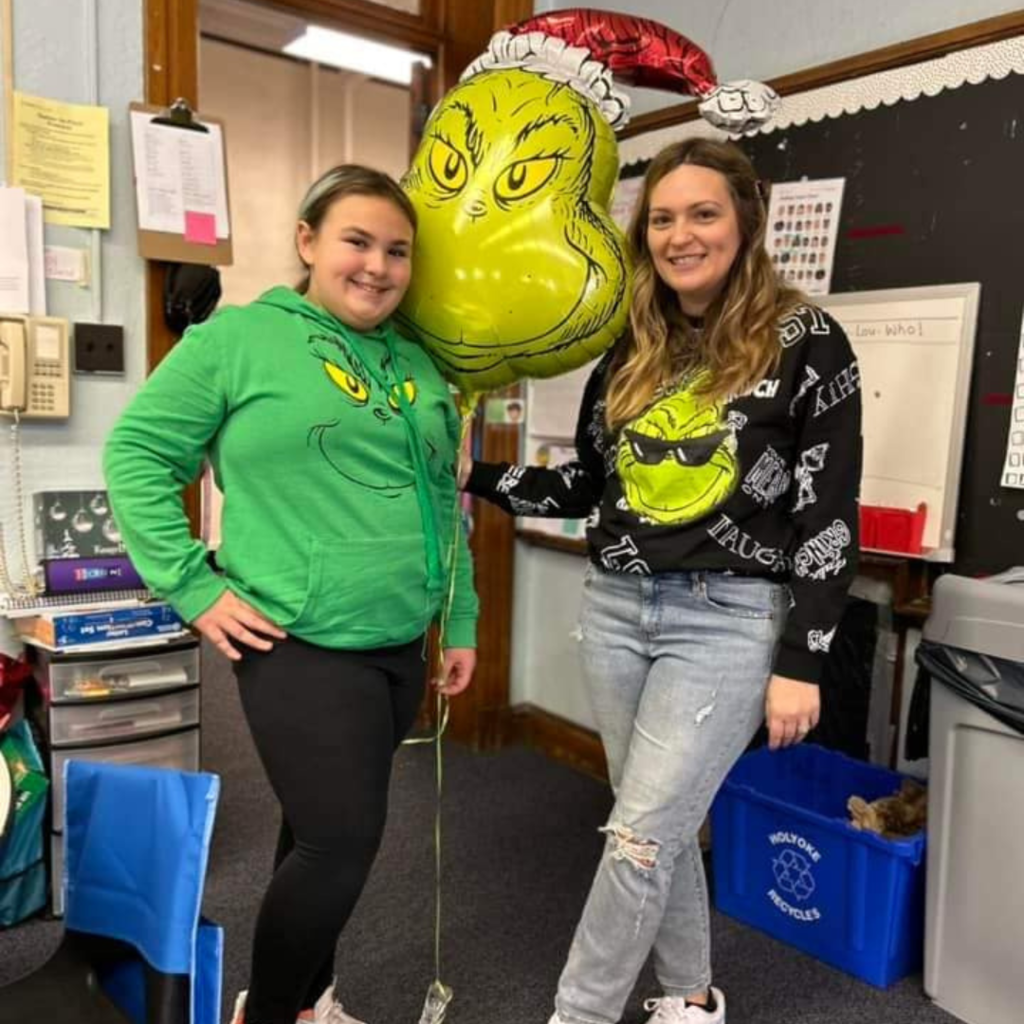 Teacher and former student wearing Grinch inspired clothing.