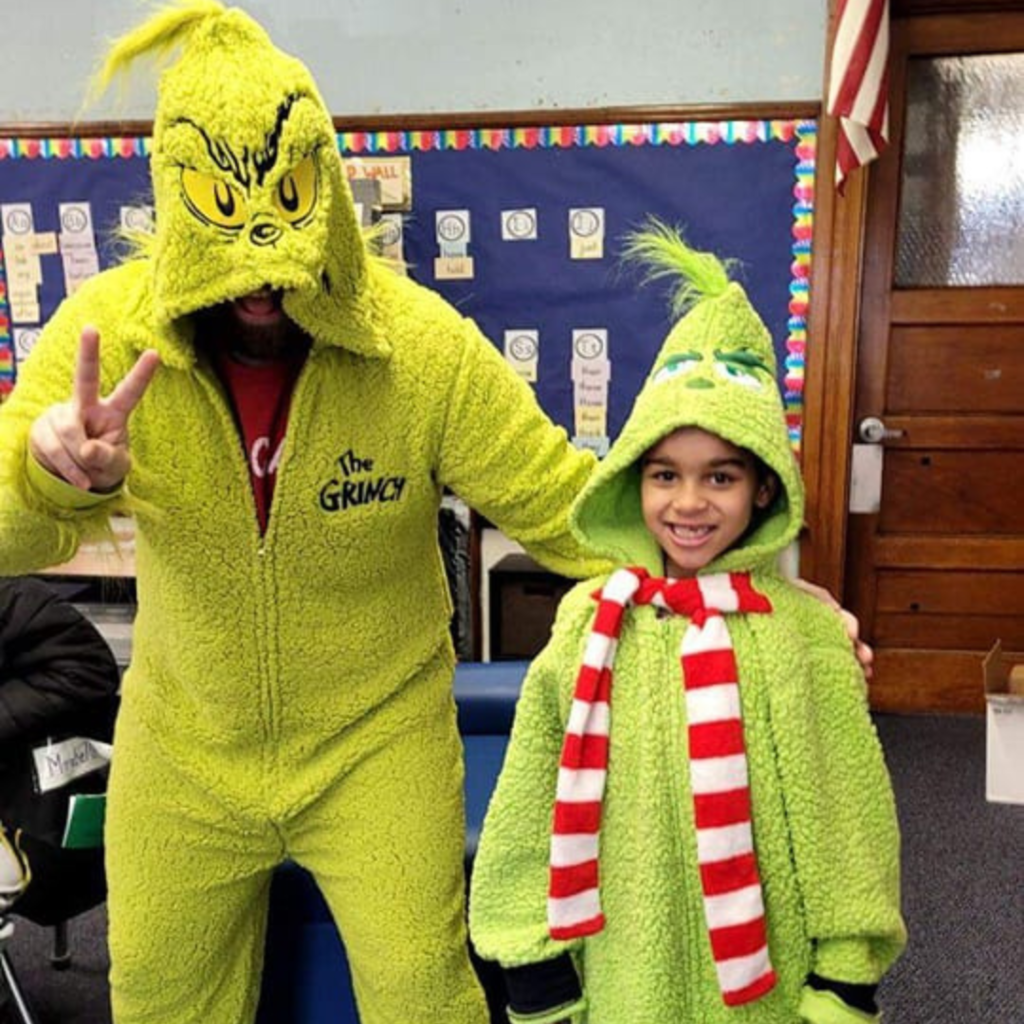 Student and teacher wearing matching Grinch inspired clothing.