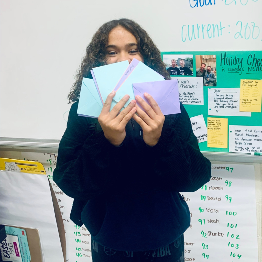Student holding a bunch of gift cards.