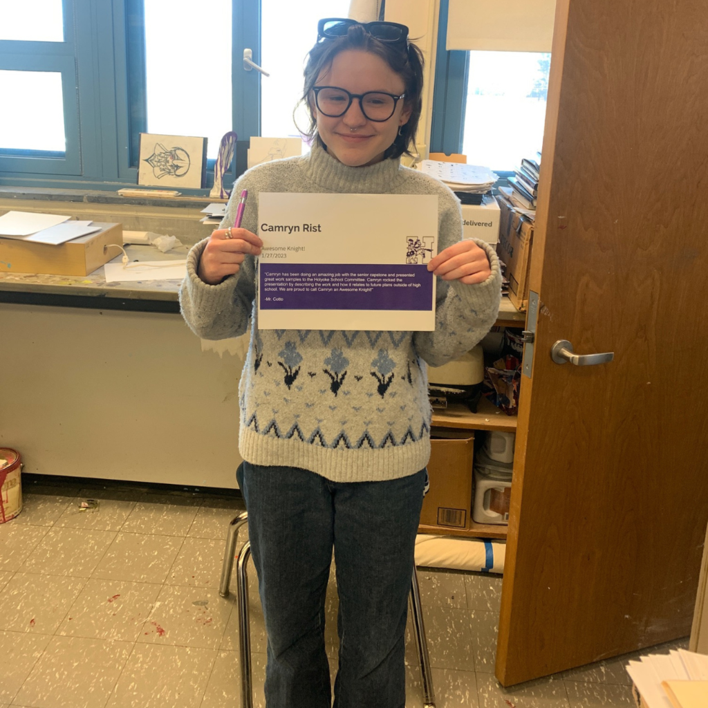 Camryn Rist  in a classroom holding the awesome knight certificate 