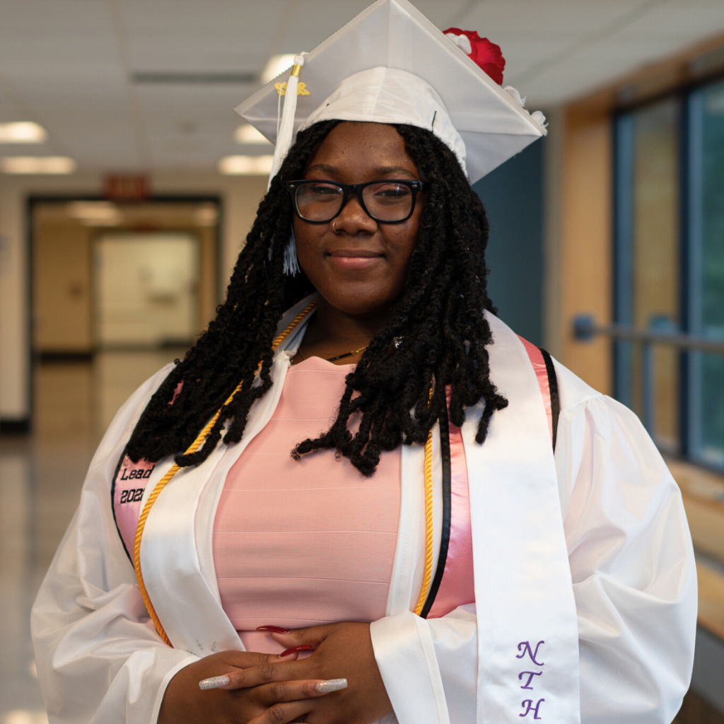 A student in her white cap and gown on graduation day.